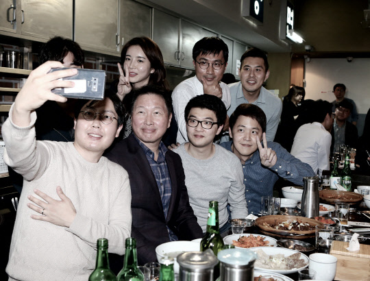 최태원 SK그룹 회장(앞줄 왼쪽 두번째)이 지난 28일 서울 광화문 인근의 한 대중음식점에서 저녁식사를 겸한 번개 행복토크를 열고 구성원들과 함께 사진을 찍고 있다.    SK 제공